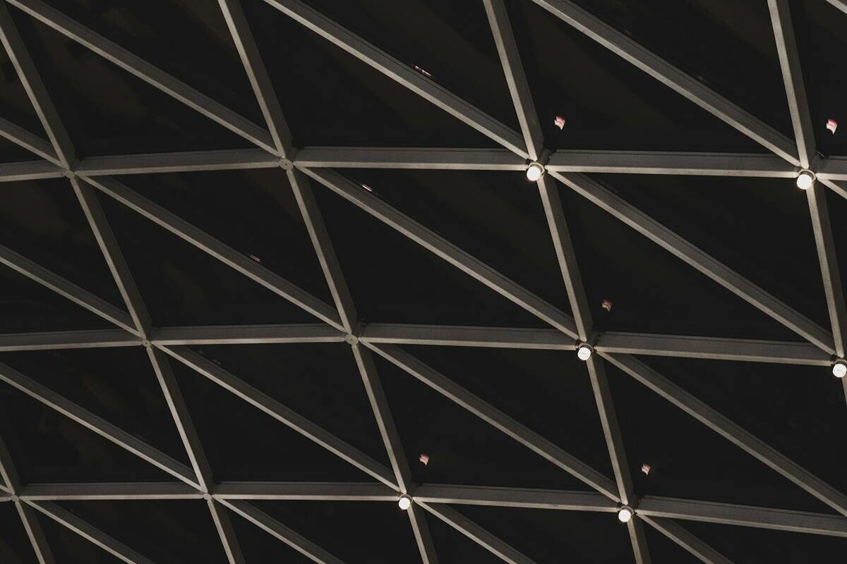 Abstract view of a geometric architectural ceiling structure with lighting.
