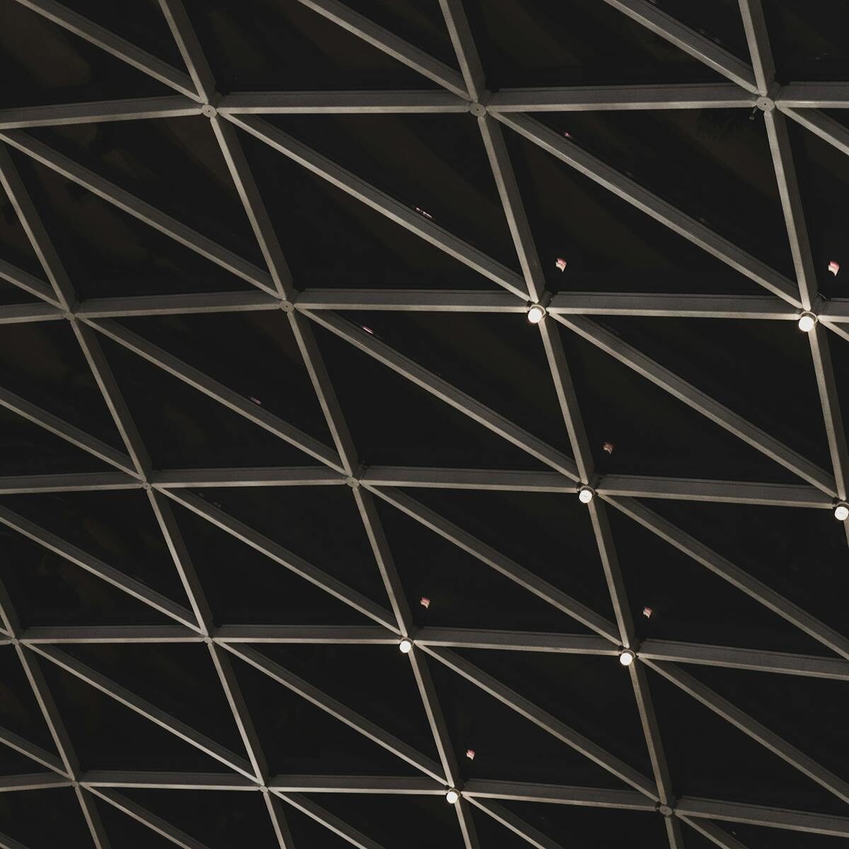 Abstract view of a geometric architectural ceiling structure with lighting.